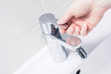 El bir krom musluk kolu üzerinde su dönüş için hazır