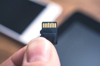 Erkek parmak Tablet ve Smartphone ile bir mikro Sd Kart arka planda, ölçüde Disk alanı kavramı Holding