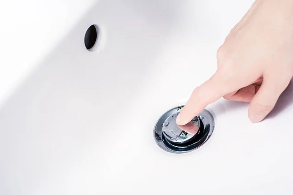 Female Hand With Finger On An Open, Pop-Up Drain Plug, Ready To Press And Close The Drain — Stock Photo, Image