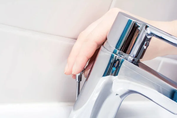 Bir sopa drenaj Tak açmak için krom musluk arkasında basarak el