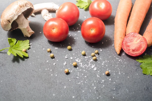 Keuken ingrediënten zoals tomaten, paddestoelen, wortelen of specerijen op leisteen steen — Stockfoto