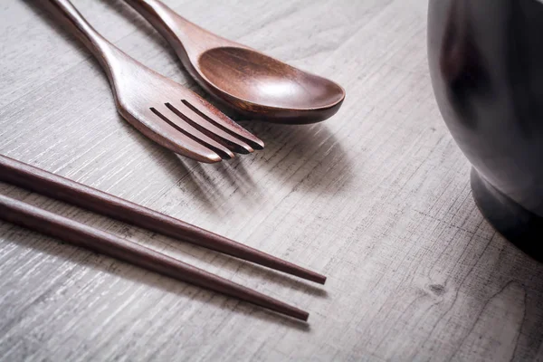 Ensemble en bois de fourchette, couteau et baguettes à côté d'un bol sur une table - Manger concept alimentaire chinois — Photo