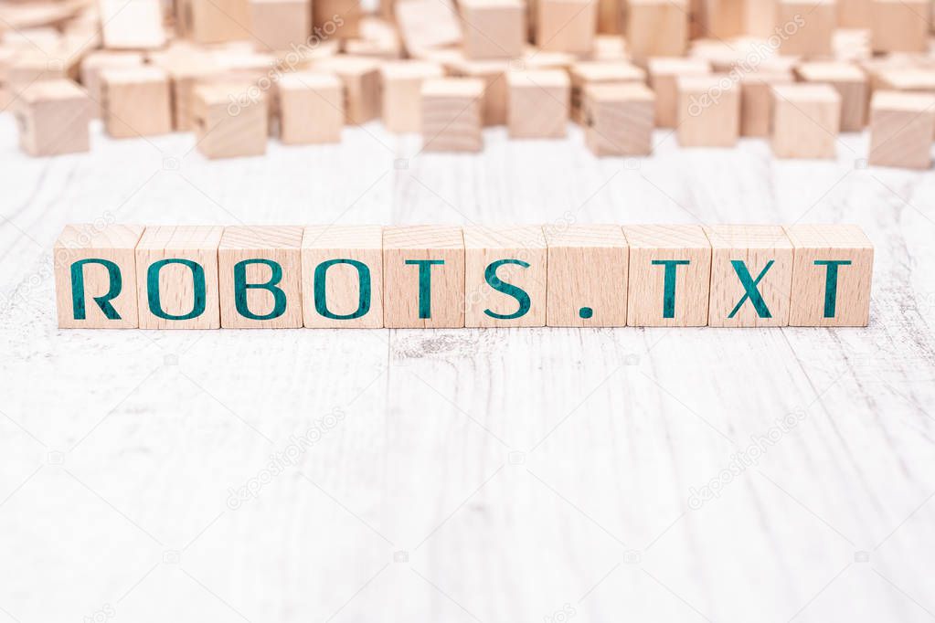 The Word Robots.txt Formed By Wooden Blocks On A White Table