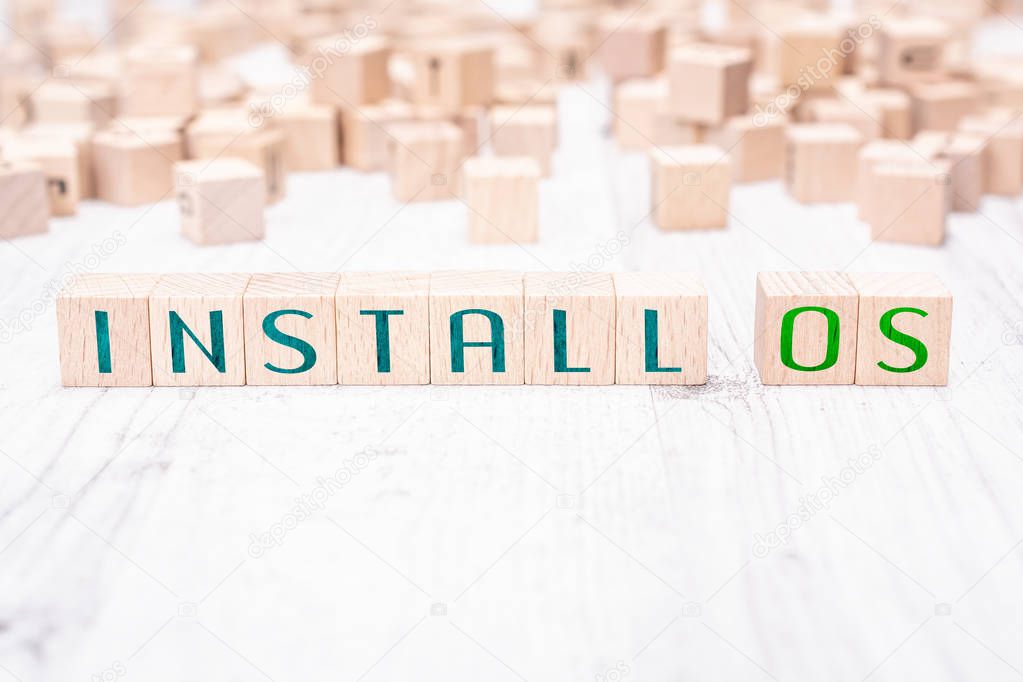 The Words Install OS Formed By Wooden Blocks On A White Table