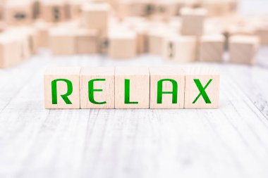 Kelime Relax ahşap bloklar üzerinde beyaz bir tablo tarafından oluşturulmuş