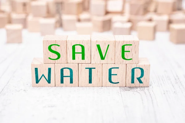 Słowa oszczędzanie wody tworzą drewniane klocki na stół biały — Zdjęcie stockowe