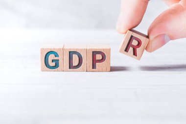 Word Gdpr ahşap bloklar tarafından kurulan ve beyaz bir masada erkek parmak göre düzenlenmiş