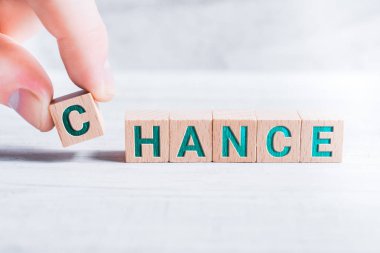 Word şans ahşap bloklar tarafından kurulan ve beyaz bir masada erkek parmak göre düzenlenmiş