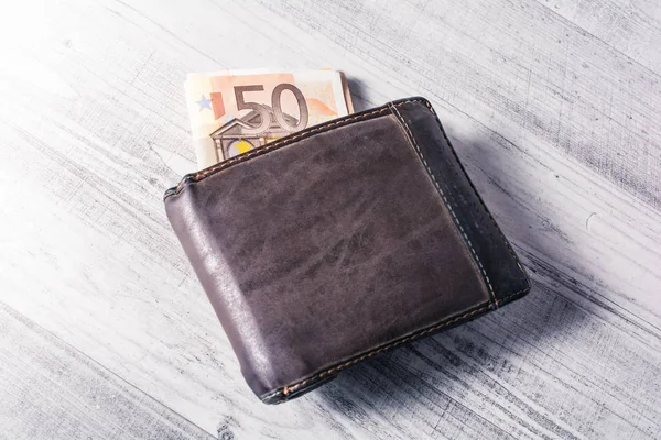 Bir 50 Euro Bill gösteren bir tablo üzerinde kahverengi deri cüzdan dışarı yarısı — Stok fotoğraf