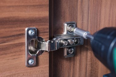 Bir elektrikli tornavida, DIY kavramı ile bir dolap menteşe ayarlama