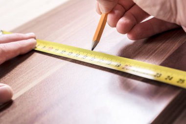 Bir ahşap tahta ölçme ve bir işareti bir kalem ile yapım marangoz