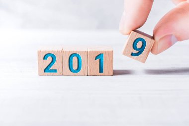 Yıl 2019 tahta bloklar tarafından kurulan ve beyaz masada erkek parmak göre düzenlenmiş