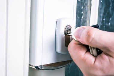 Erkek el bir güvenlik kapı kilidi, bir anahtar kullanarak önlemek hırsızlık kavramı