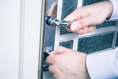 Kapıyı tutan erkek el ele ve bir anahtar ile kapıyı kilitlemeye önlemek hırsızlık kavramı