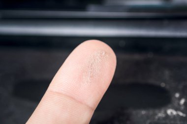Macro Of A Finger Streaked Through Dust On A Black Surface clipart