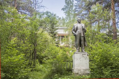 Russia.  Yekaterinburg.   Lenin sculpture in the summer pine forest . clipart