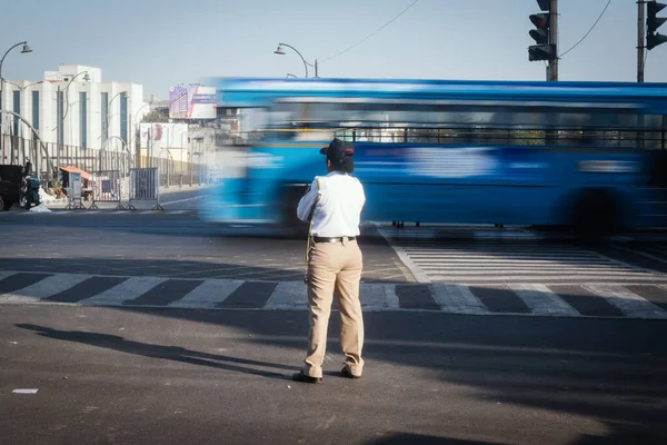 A female traffic officer standing on road and controlling traffic