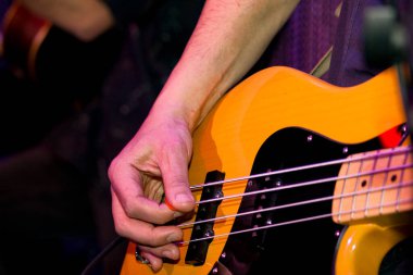 Konserde elektro gitar çalan bir adam..