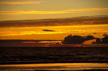 Baltık Denizi kıyılarında gün batımı, kum ve güneş, soğuk