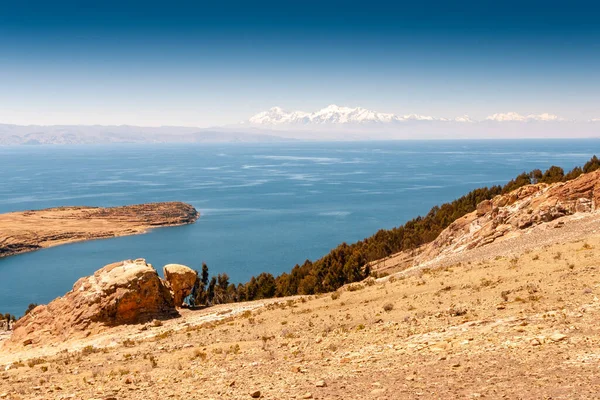 ボリビアを背景に雪の山のある青い湖の海岸 — ストック写真