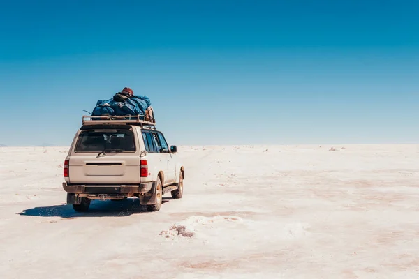 Bolivya, Salar de Uyuni 'ye giden beyaz bir SUV.