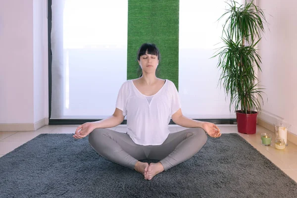 Mujer Posición Yoga Meditando Delante Ventana Casa Hay Velas Plantas — Foto de Stock