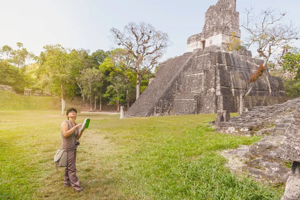 ジャングルで本の情報を探している女性探検家 ピラミッドマヤの隣に — ストック写真