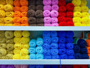 Satışa hazır yün yumakları olan raflar.