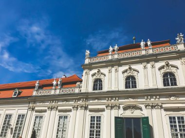 Turuncu çatılı ve mavi gökyüzü olan tarihi binanın bir parçası. Avusturya 'da turistik bir yer. Şehir merkezindeki antik mimari cephesi. Viyana 'daki Belveder Sarayı.