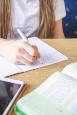 Kitabın, telefonun ve not tutmanın yanındaki eli kalem ile kapat.