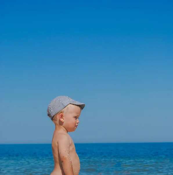 Menino pequeno olhando na frente na vista do mar — Fotografia de Stock