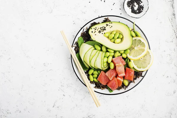 Taze deniz ürünleri mutfak. Somon, avokado, soya fasulyesi, salatalık, turp, mikro Yeşiller, susam bir kâse poke, yabani pirinç Top görünümü