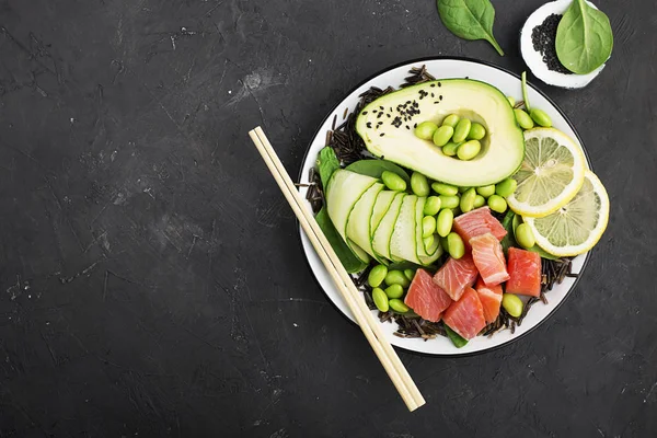 Taze deniz ürünleri mutfak. Somon, avokado, soya fasulyesi, salatalık, turp, mikro Yeşiller, susam bir kâse poke, yabani pirinç Top görünümü