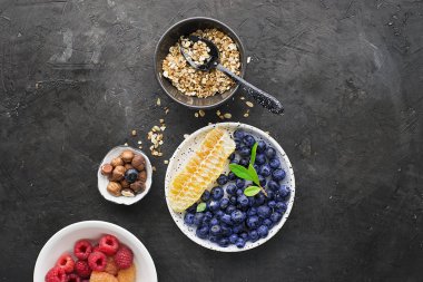 Sağlıklı kahvaltı yemek için malzemeler: ahududu, yaban mersini, fındık, portakal, muz, üzüm mavi, yeşil elma kivi üst görünümü