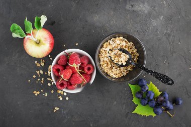 Sağlıklı kahvaltı yemek için malzemeler: ahududu, yaban mersini, fındık, portakal, muz, üzüm mavi, yeşil elma kivi üst görünümü
