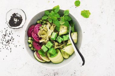Sebze yaz meyve kase detoks. Vejetaryen Sağlıklı yiyecekler. Salata, marul yaprakları, ahududu, yeşil bezelye, salatalık, havuç, daikon, üst görünüm Yenilebilir çiçekler