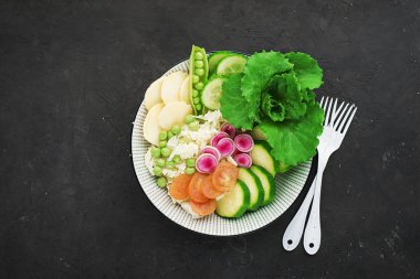 Sebze yaz meyve kase detoks. Vejetaryen Sağlıklı yiyecekler. Salata, marul yaprakları, ahududu, yeşil bezelye, salatalık, havuç, daikon, üst görünüm Yenilebilir çiçekler