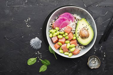 Taze deniz ürünleri yemek tarifi. somon gravlax kase taze karides, kahverengi pirinç, salatalık, turşu tatlı soğan, turp, beyaz siyah susam ile alakart soya fasulye edamame ile poke. Gıda kavramı poke kase