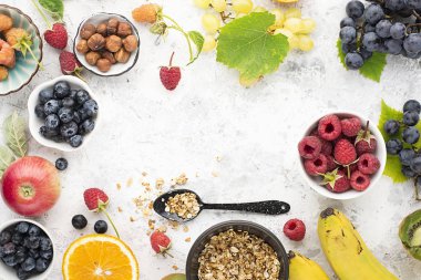 Çilek meyve granola yulaf ezmesi ahududu, yaban mersini, muz, bal, peteğin, elma, kivi hafif bir arka plan üzerinde. Üstten Görünüm. Kopya alanı