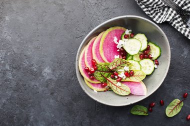 Sağlıklı gıda. Karpuz turp, salatalık, pirinç, nar taneleri, kuzukulağı, Kırmızı damarlar salata bir kase karanlık bir arka plan üzerinde. Üstten görünüm. Kopya alanı.