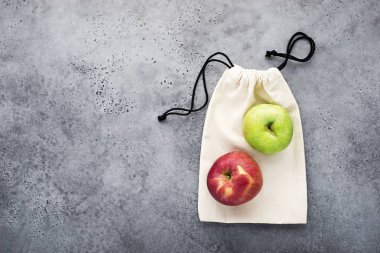 Sıfır atık alışveriş evi. Eko çanta satın sebze, meyveler için bir ışık gri arka plan üzerinde pamuk made. Kopya alanı, üstten görünüm