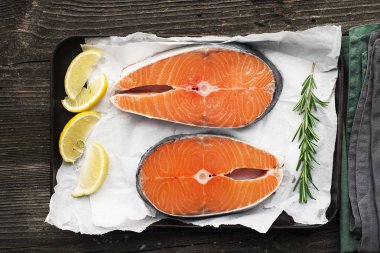 Limon, tuz, bir ahşap zemin üzerine biberiye pişirme önce çiğ biftek somon. Üstten görünüm.