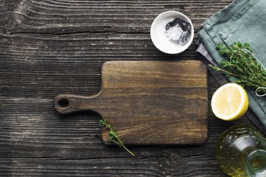 eski ahşap kesme tahtası, limon, kekik, deniz tuzu ile üstten görünüm