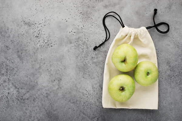 Eco-tas voor producten. Appels op de achtergrond van een linnen tas op een lichtgrijze achtergrond. Kopiëren van ruimte — Stockfoto