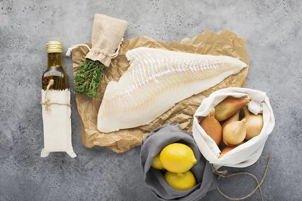 Nul afval keuken. Ingrediënten voor gezonde voeding. Witte zeevis kabeljauw filet, citroenen, sjalot uien en greens. Bovenaanzicht. — Stockfoto