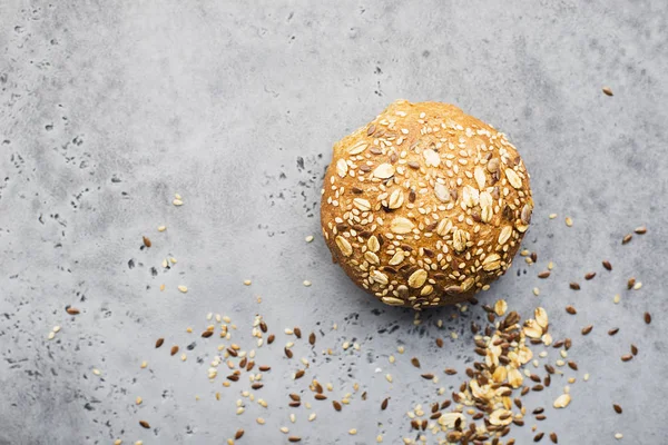 Pan de trigo Hamburguesa con semillas de lino, harina de avena, semillas de sésamo sobre un fondo gris claro. Vista superior, espacio . — Foto de Stock