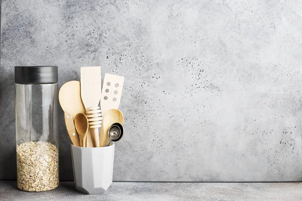 Kitchen gray concrete wall. Shelf with kitchen tools, appliances, a jar of oatmeal. Horizontal, space.