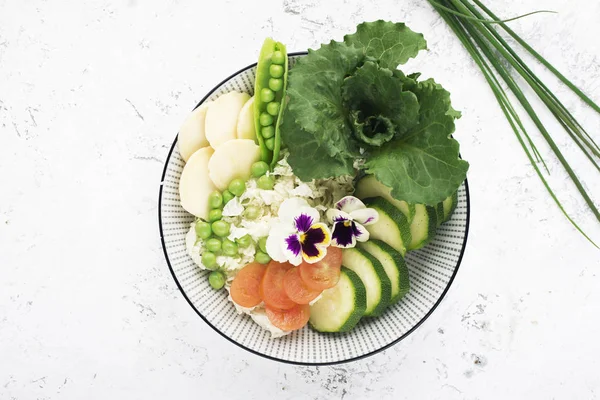 Hermosa ensalada de verduras saludables con vitaminas. Pepinos, col, daikon, lechuga, guisantes jóvenes en el mismo tazón. Vista superior . — Foto de Stock