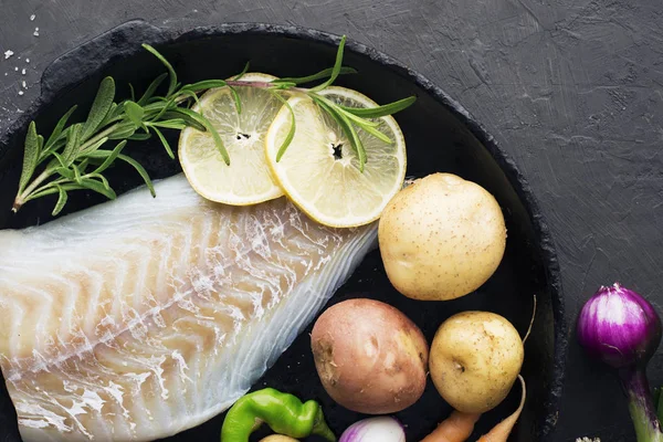 Bacalhau. Peixe cru branco de mar fresco antes de cozinhar em um com legumes frescos: cebolas doces e limões. Vista superior. Conceito alimentar — Fotografia de Stock