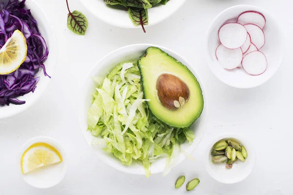 Schoon voedsel. Verse rauwe groenten en sla bladeren te bereiden van een gezonde snack maaltijd salade. Bovenaanzicht. Op een lichte achtergrond. — Stockfoto